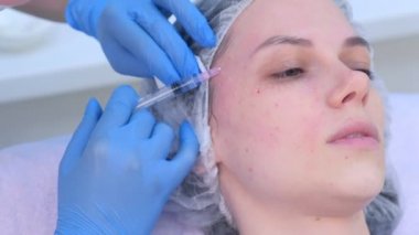 Kozmetik uzmanı kadın cildine birden fazla enjeksiyon yapıyor..