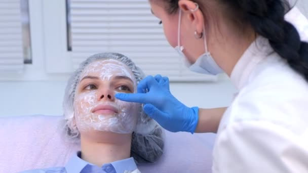 Kosmetologe cremt die Haut vor der Biorevitalisierung mit Betäubungsmitteln ein. — Stockvideo