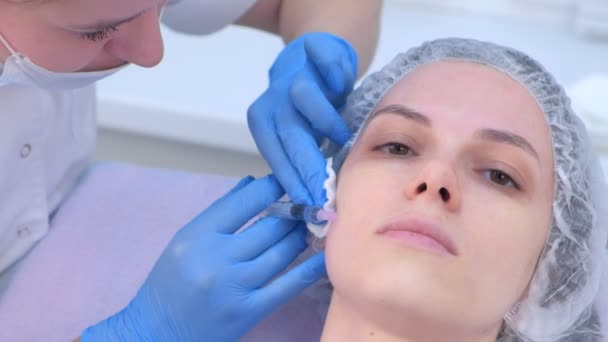 Врач делает несколько инъекций женской коже лица во время мезотерапии. — стоковое видео