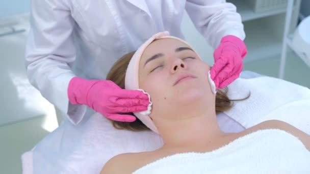 Cosmetologi mani peeling pulire le donne viso batuffoli di cotone in clinica di bellezza . — Video Stock