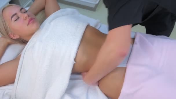 Man doctor making sculptural body lift massage to woman on waist in clinic. — Stock Video