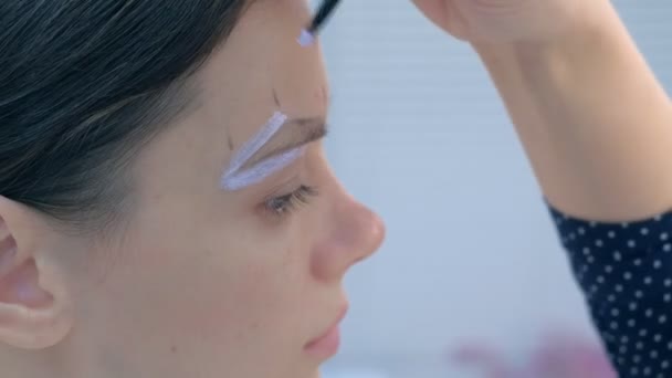 Cosmetoloog schilderen borstel vorm van wenkbrauwen vrouw voor tint procedure. — Stockvideo