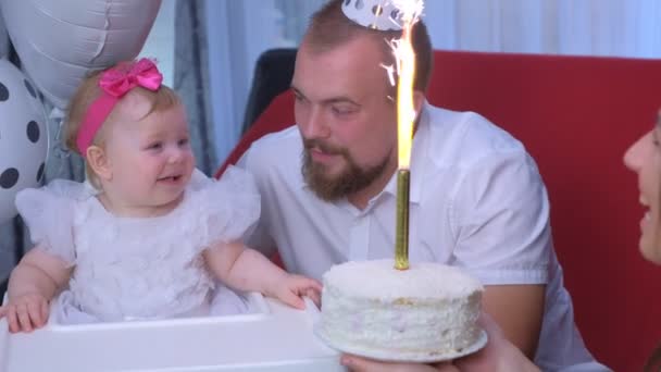 Mom gives daughter a cake with candle on birthday party of one year baby girl. — ストック動画