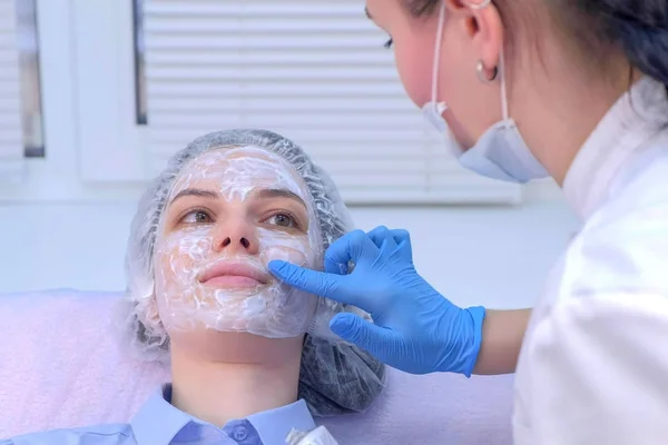 Cosmetoloog aanbrengen crème met verdoving op de huid voor biorevitalisatie. — Stockfoto