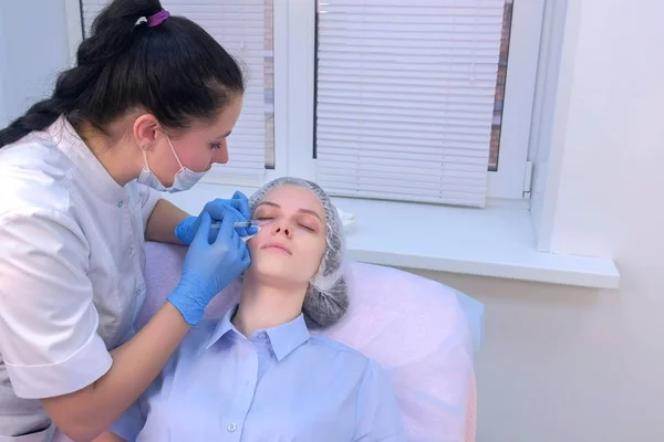 Cosmetoloog het maken van meerdere injecties biorevitalisatie in vrouw gezicht huid. — Stockfoto