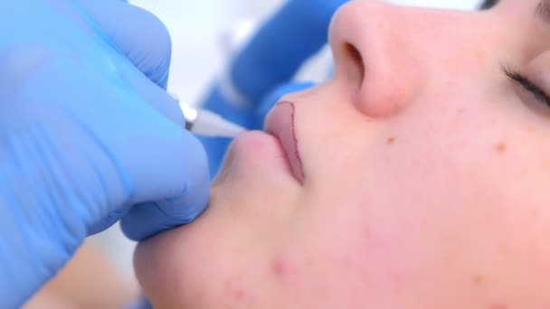 Beautician applying permanent makeup on lips using tattoo machine, closeup view. — Stock Video