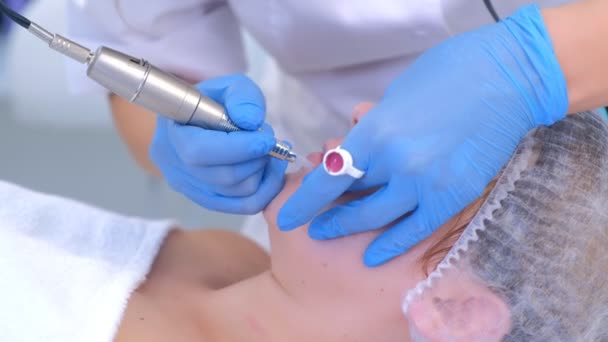 Schoonheidsspecialiste het aanbrengen van permanente make-up op de lippen maakt contour met behulp van tattoo machine. — Stockvideo