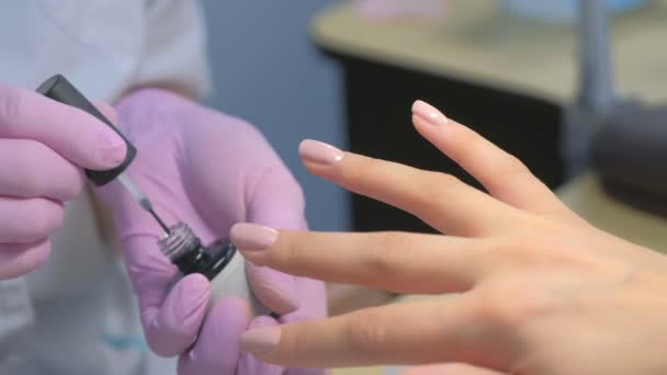 Manicurist master är att måla klienter naglar med överlack, händer närbild. — Stockvideo