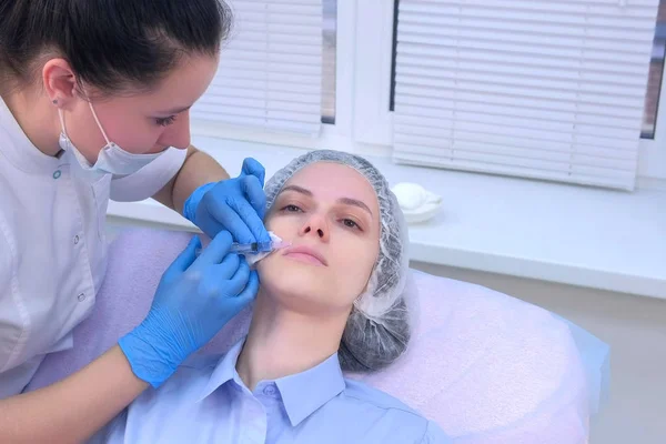Médico está fazendo múltiplas injeções na pele do rosto das mulheres durante a mesoterapia. — Fotografia de Stock