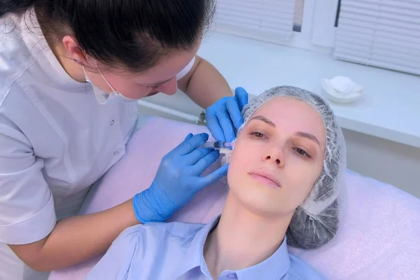 Kosmetolog gör flera injektioner biovitalisering hos kvinna ansikte hud. — Stockfoto