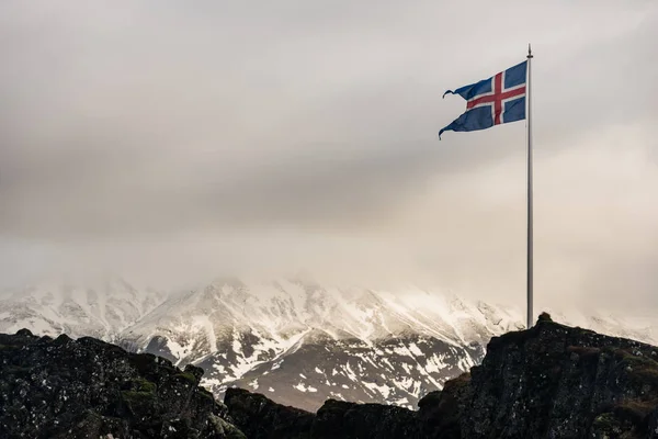 Arka planda dağların İzlandalı bir bayrak bayrak direği — Stok fotoğraf