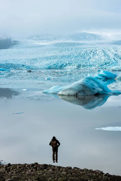 Springt der Mann auf den Hintergrund des Gletschers — Stockfoto