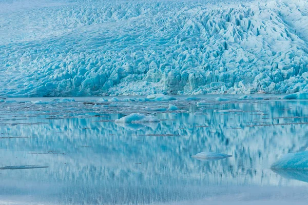 Wide angle view of glacier face with blue ice