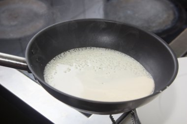 Aşçı dökülen tavada meyilli krep pişirme.