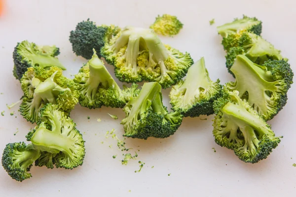 Broccoli tagliati a pezzi sdraiati sulla tavola . — Foto Stock