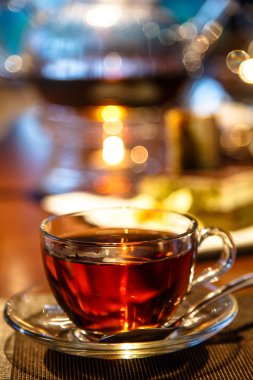 Siyah çay cam bardak ve çaydanlık bir mum ile standları 