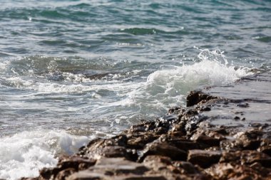 Dalgalar kayalar ve su sıçramalarına bölünürler. Akşam.