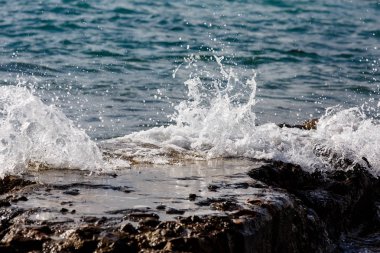 Dalgalar kayalar ve su sıçramalarına bölünürler. Akşam.