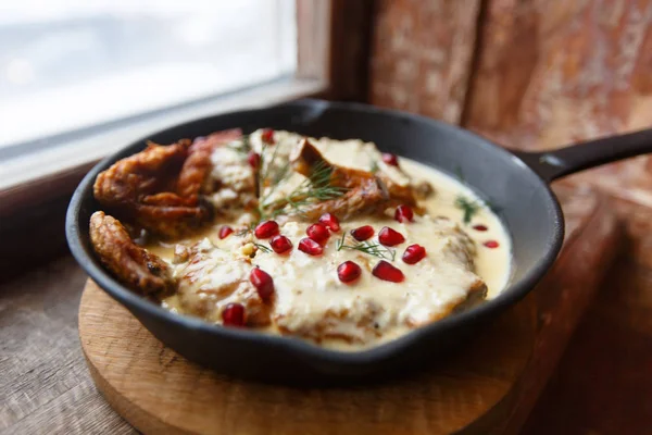 Pollo cotto con salsa bianca su una padella nera — Foto Stock