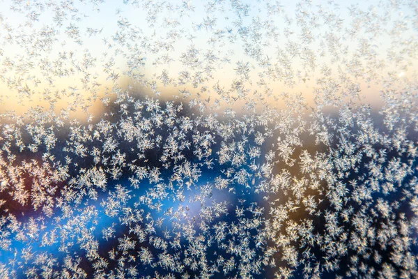 Weinig frosty patronen op glas, zichtbaar sneeuwvlokken. Winter in R — Stockfoto