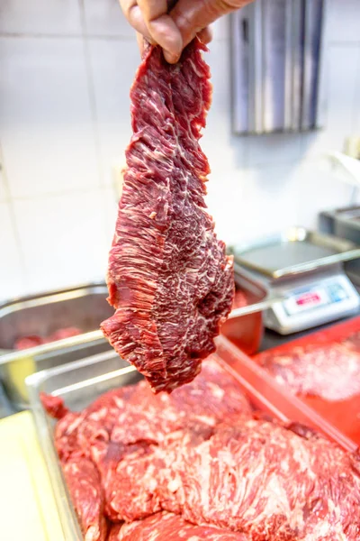 Raw steak "skirt", "butcher's " or "Machete" in the hands o — Stock Photo, Image