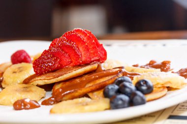 Krep yerken üzerine çikolata sos ile yalan çilek dilimlenmiş.