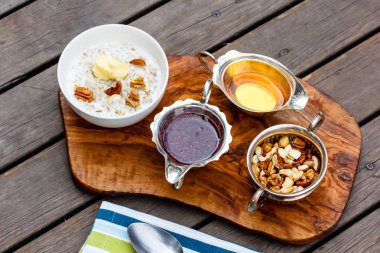 Yulaf ezmesi bir kapta, bal, reçel, fındık ve brea standı