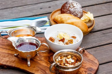 Yulaf ezmesi bir kapta, bal, reçel, fındık ve brea standı