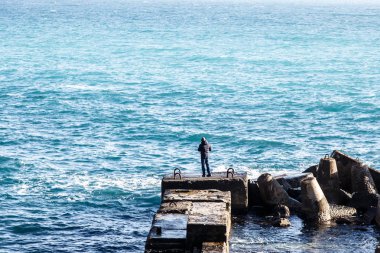 Dostum denizde yakalar balık beton bloklar üzerinde duruyor.
