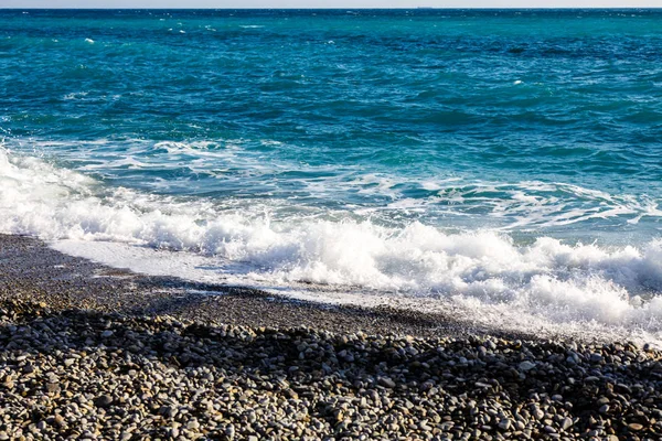 Dalgaların çakıl plaj üzerine haddelenmiş.