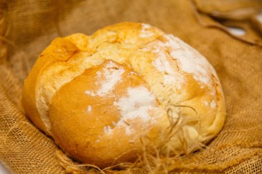 Ev yapımı yuvarlak ekmek buğday unu gelen kaba kumaş üzerinde yatıyor..