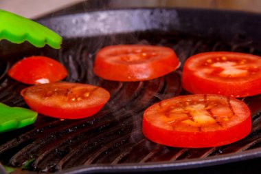 Daireler dilimlenmiş domates ızgara kavrulmuş.