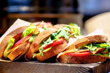 Jambon, domates ve maydanoz ile sandviç kağıt sarılı.