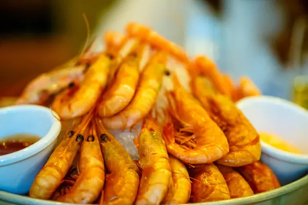 Μεγάλες πορτοκαλί βραστές γαρίδες, τοποθέτηση σε ένα πιάτο με πάγο. — Φωτογραφία Αρχείου