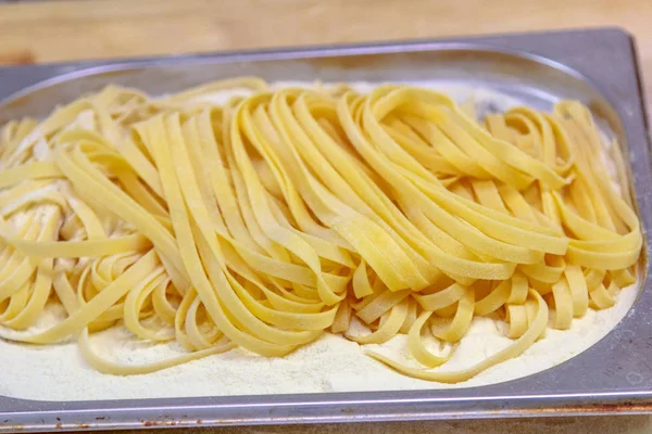 Verse pasta, die handgemaakte Tagliatelle op tafel ligt, in afwachting van de voorbereiding — Stockfoto