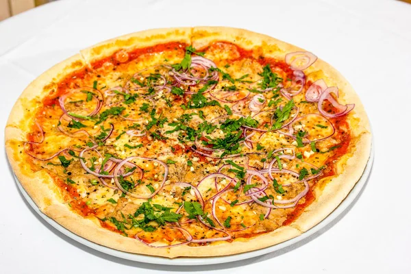 Пицца с тунцом, сыром, помидорами, красный лук на столе . — стоковое фото