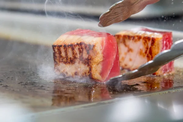 Кусочки сырого тунца, жареного на гриле. Капли масла в воздухе — стоковое фото
