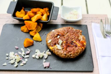 Üzerine soğan ve patates kızartması ile sığır kıyılmış biftek ızgara bir