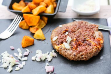 Üzerine soğan ve patates kızartması ile sığır kıyılmış biftek ızgara bir