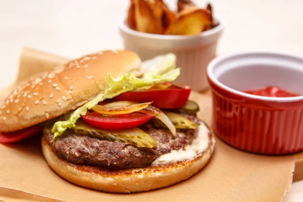 Hamburguesa con tomate, pepino, lechuga y cebolla a la parrilla . —  Fotos de Stock