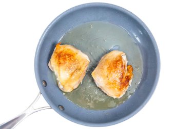 Tavuk uyluk bir tavada kızarmış. İzoleli