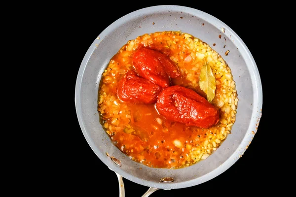 Консервированные помидоры, чеснок жарятся в масле на сковородке. . — стоковое фото