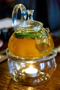 Bir stand bir mum ile cam demlik çay.