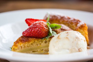 Bir parçası cheesecake taze çilek, nane ve bir kaşık ile 