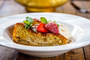 Bir parçası cheesecake taze çilek, nane ve bir kaşık ile 