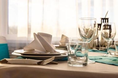 Masanın üzerinde bir tabakta keten peçete ile beyaz bir tablec kaplı