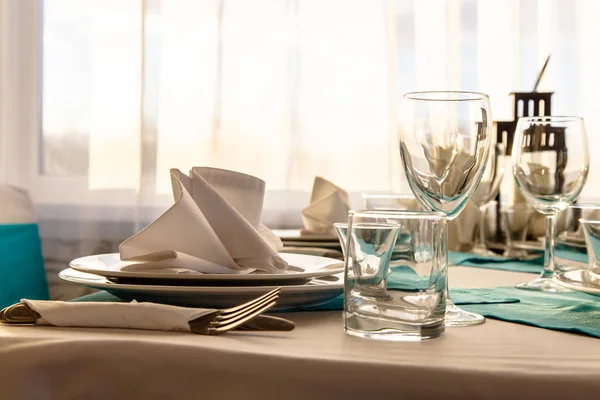 Leinen Serviette auf einem Teller auf dem Tisch mit einem weißen Tischtuch bedeckt — Stockfoto