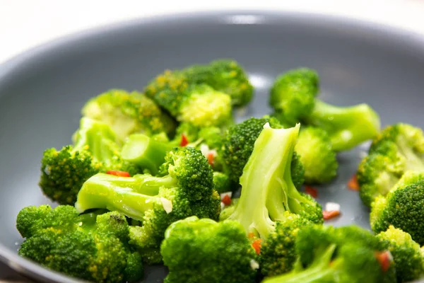Raw broccoli is roasted in the pan with the chilli.