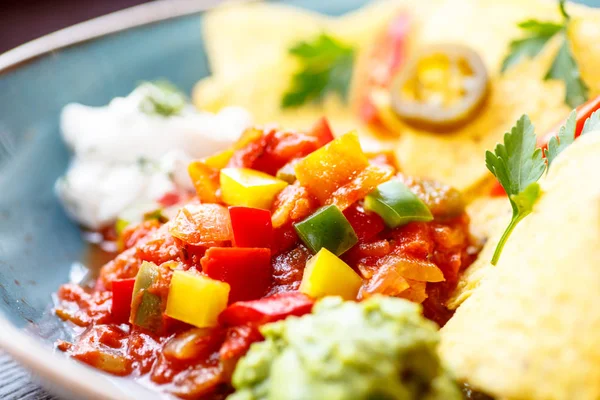 Nachos con verdure, peperoni e salsa sono sul piatto . — Foto Stock