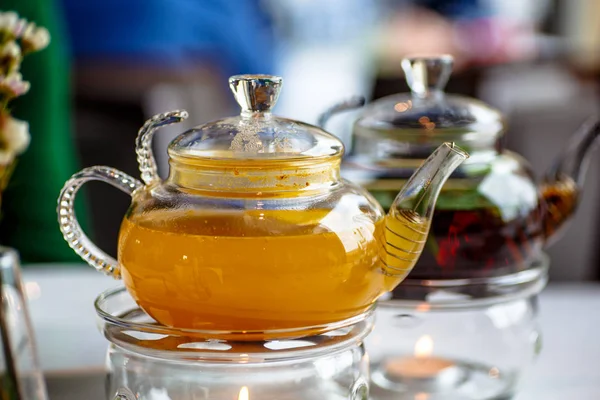 Te från havtorn i en glas tekanna med ett ljus. — Stockfoto